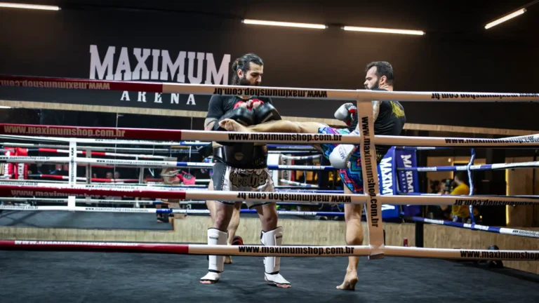 Treinamento de kickboxing na academia Maximum, com dois atletas praticando golpes.