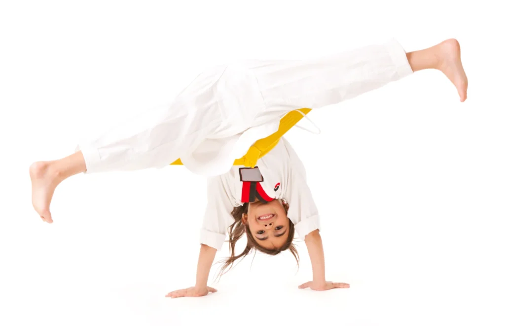 Criança praticando handstand mostrando habilidade em capoeira.