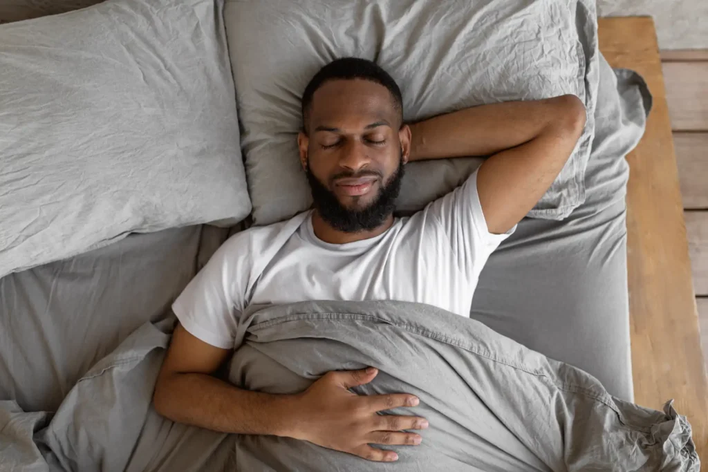 homem pós-treino de luta relaxado na cama com conforto