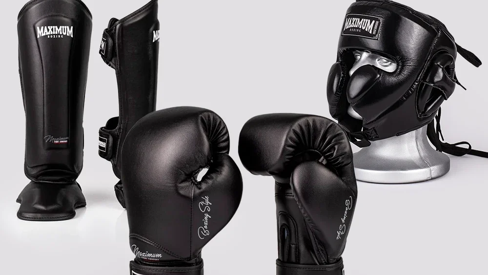 Equipamentos de boxe preto incluindo luvas, bandagens, capacete, caneleiras e protetor bucal, ideais para treinamento e luta profissional.