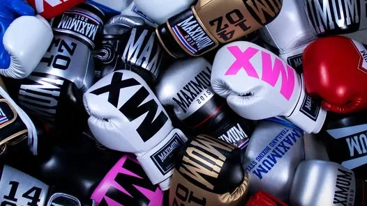 Várias luvas da Maximum boxing em cores variadas como preto, branco, vermelho, dourado e rosa.
