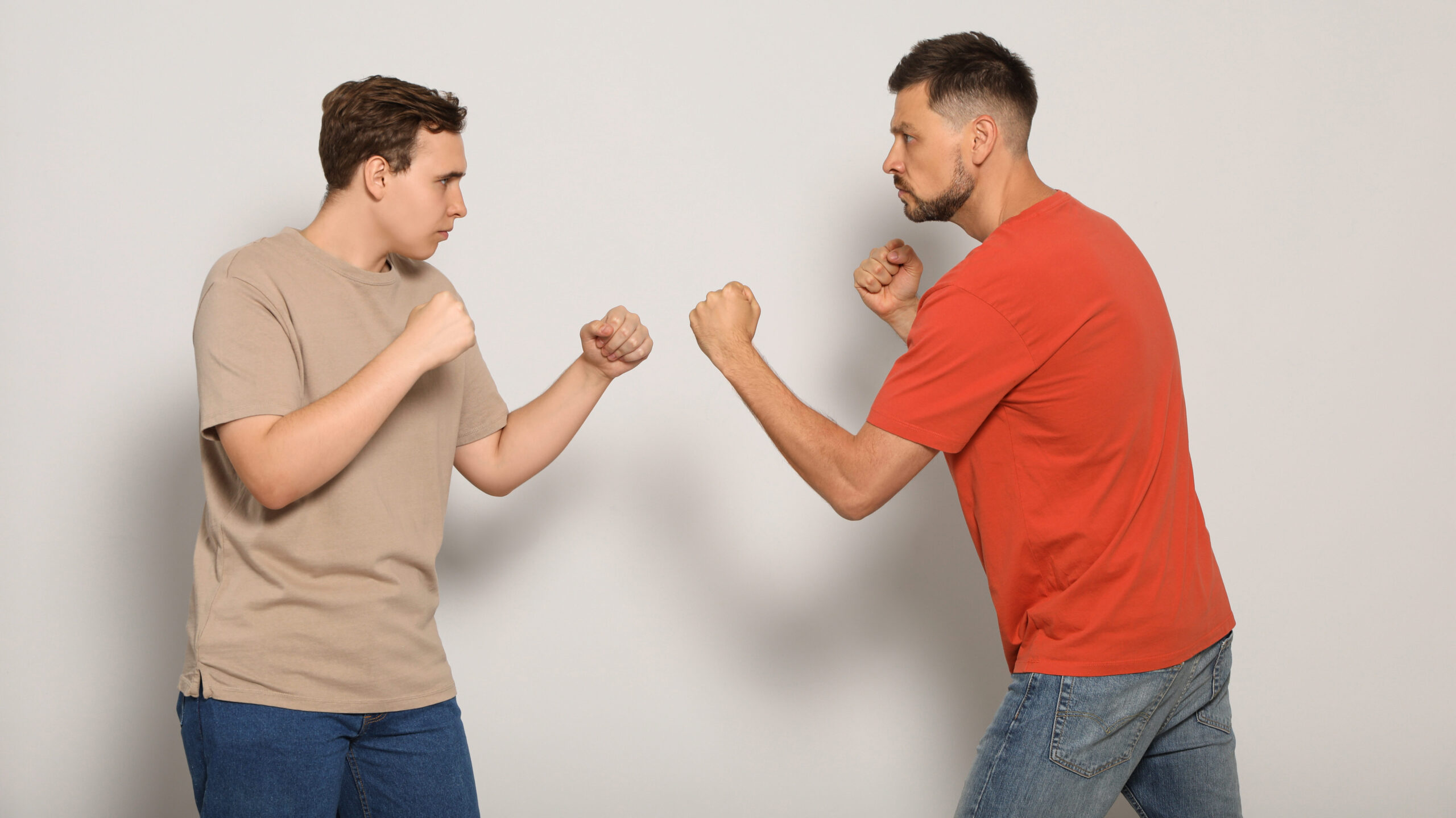 Dois homens de frente para o outro em posição de defesa