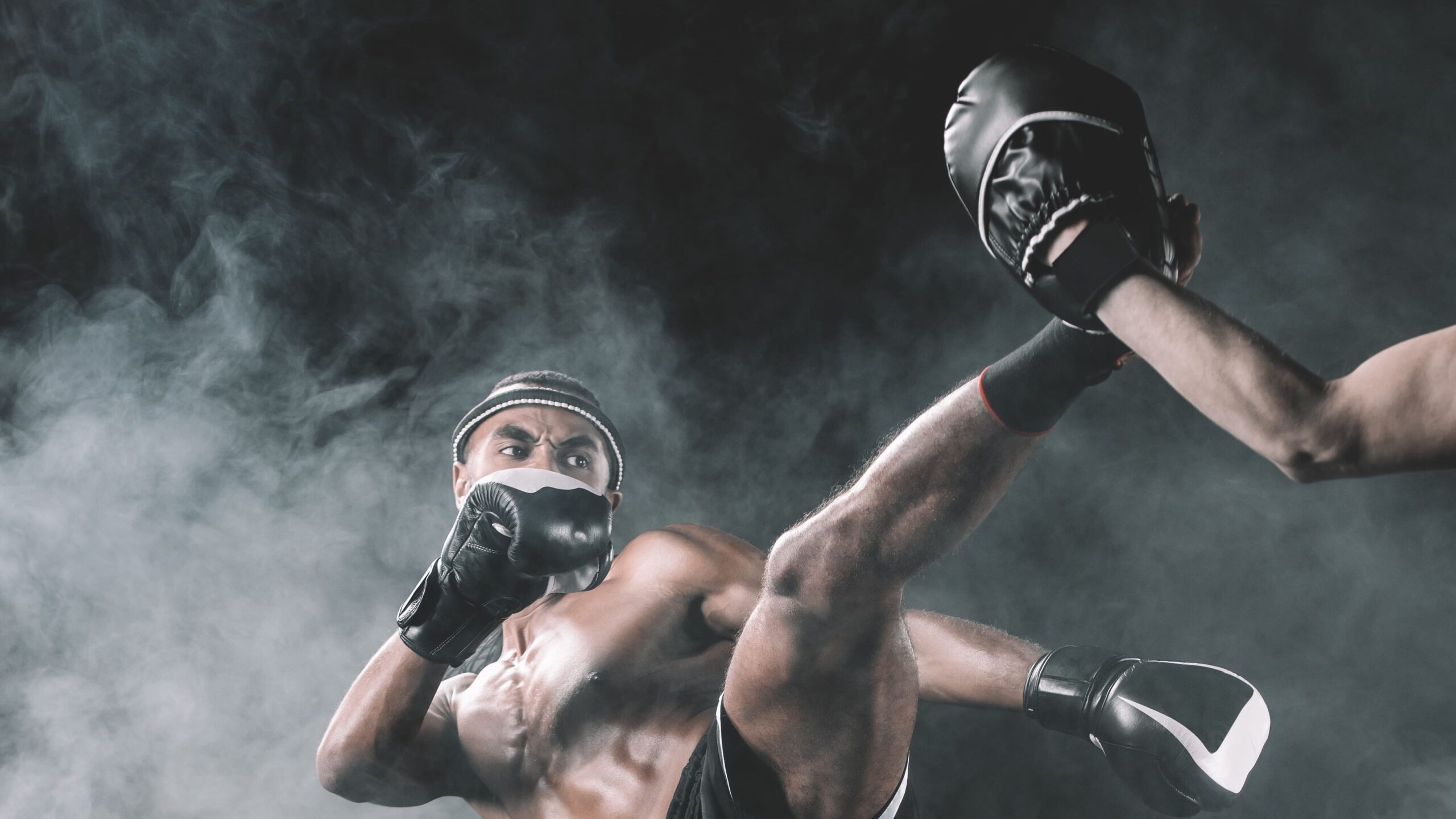 Dois lutadores de boxe em pé trocando golpes com luvas, em uma cena dramática com fumaça e iluminação azul, no ringue